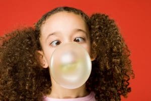 little girl blowing bubble gum bubble
